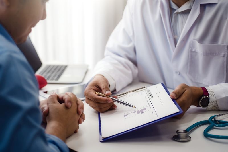 A pharmacist speaks to a patient at the counter Medication Therapy Management